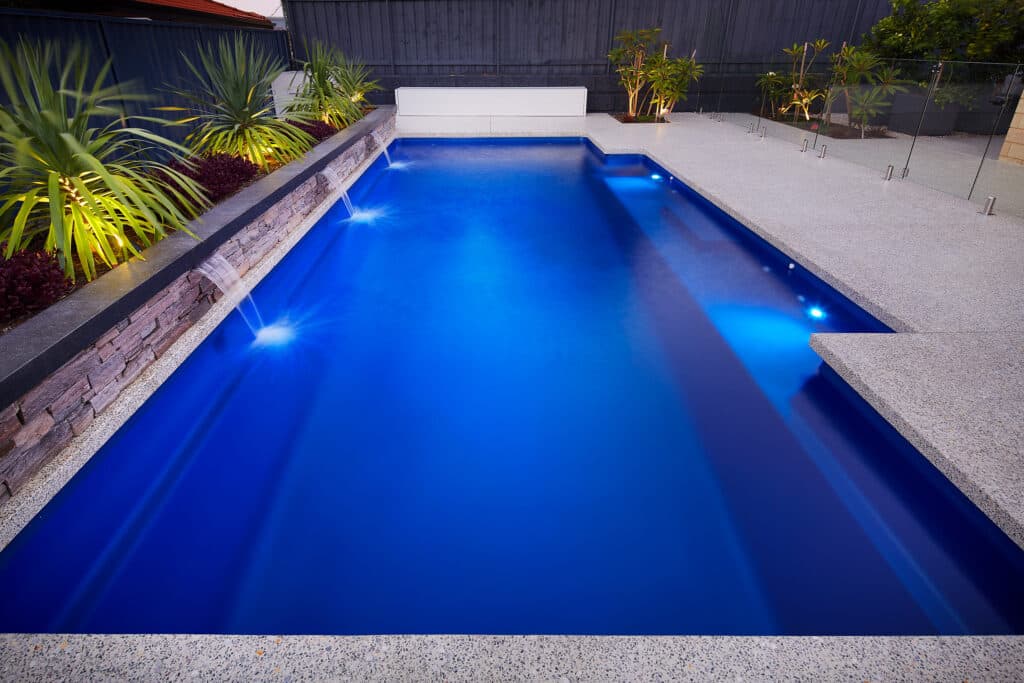 swimming pool with water feature at night